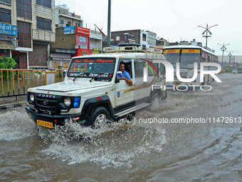 Vehicles are moving through the waterlogged Sikar Road following heavy monsoon rains in Jaipur, Rajasthan, India, on Monday, August 12, 2024...