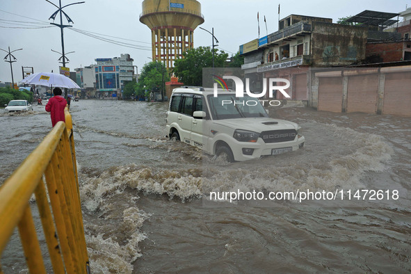 Vehicles are moving through the waterlogged Sikar Road following heavy monsoon rains in Jaipur, Rajasthan, India, on Monday, August 12, 2024...