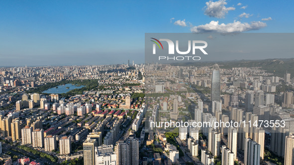 The blue sky and white clouds are silhouetted against urban buildings in Jinan, China, on August 12, 2024. 