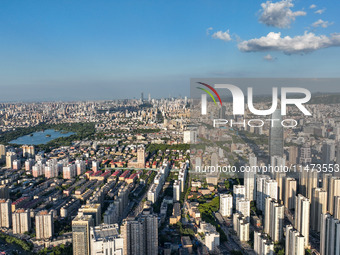 The blue sky and white clouds are silhouetted against urban buildings in Jinan, China, on August 12, 2024. (