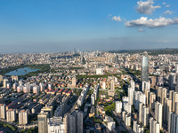 The blue sky and white clouds are silhouetted against urban buildings in Jinan, China, on August 12, 2024. (