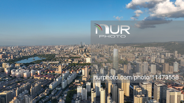 The blue sky and white clouds are silhouetted against urban buildings in Jinan, China, on August 12, 2024. 