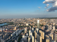 The blue sky and white clouds are silhouetted against urban buildings in Jinan, China, on August 12, 2024. (