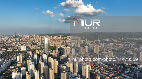 The blue sky and white clouds are silhouetted against urban buildings in Jinan, China, on August 12, 2024. 