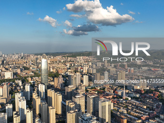 The blue sky and white clouds are silhouetted against urban buildings in Jinan, China, on August 12, 2024. (