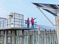 Operation and maintenance personnel are inspecting the operating power generation facilities at the ''fishery-solar hybrid project'' photovo...