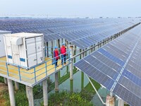 Operation and maintenance personnel are inspecting the operating power generation facilities at the ''fishery-solar hybrid project'' photovo...