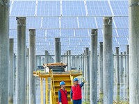 Operation and maintenance personnel are inspecting the operating power generation facilities at the ''fishery-solar hybrid project'' photovo...