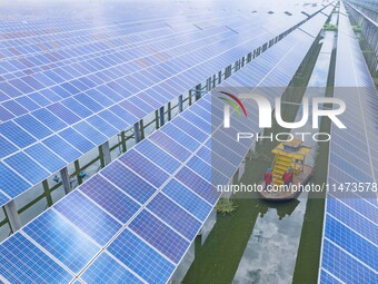 Operation and maintenance personnel are inspecting the operating power generation facilities at the ''fishery-solar hybrid project'' photovo...