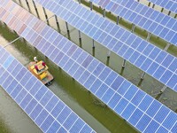 Operation and maintenance personnel are inspecting the operating power generation facilities at the ''fishery-solar hybrid project'' photovo...