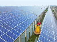 Operation and maintenance personnel are inspecting the operating power generation facilities at the ''fishery-solar hybrid project'' photovo...