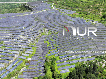 A photovoltaic power station is operating on a barren mountain in Tiankeng village, Shuiquan Town, Zaozhuang Shanting District, Shandong pro...