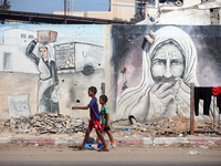 Displaced Palestinians are walking near their tents at a makeshift displacement camp set up on a roadside in Deir el-Balah in the central Ga...