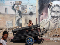 A boy is reacting as he is sitting in the back of a trailer at a makeshift displacement camp set up on a roadside in Deir el-Balah in the ce...