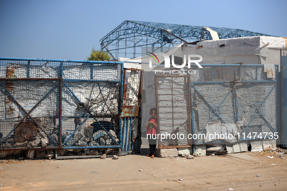 Displaced Palestinians are walking near their tents at a makeshift displacement camp set up on a roadside in Deir el-Balah in the central Ga...