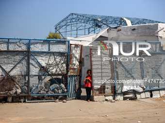 Displaced Palestinians are walking near their tents at a makeshift displacement camp set up on a roadside in Deir el-Balah in the central Ga...