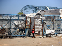 Displaced Palestinians are walking near their tents at a makeshift displacement camp set up on a roadside in Deir el-Balah in the central Ga...