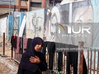 Displaced Palestinians are walking near their tents at a makeshift displacement camp set up on a roadside in Deir el-Balah in the central Ga...