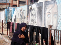 Displaced Palestinians are walking near their tents at a makeshift displacement camp set up on a roadside in Deir el-Balah in the central Ga...