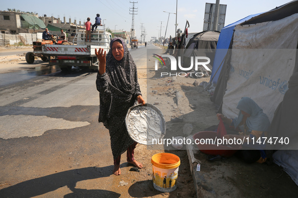 Displaced Palestinians are doing chores by their tents at a makeshift displacement camp set up on a roadside in Deir el-Balah in the central...