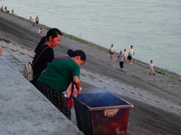 People are burning paper money to offer sacrifices to their ancestors at the Zhongyuan Festival near the banks of the Yangtze River in Yicha...