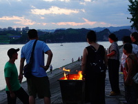 People are burning paper money to offer sacrifices to their ancestors at the Zhongyuan Festival near the banks of the Yangtze River in Yicha...