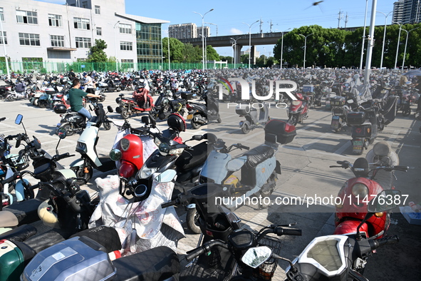 Electric bicycles are being seen at an electric vehicle parking lot near the Suzhou Rail Transit Line 11 Kunshan Huaqiao Station in Suzhou,...