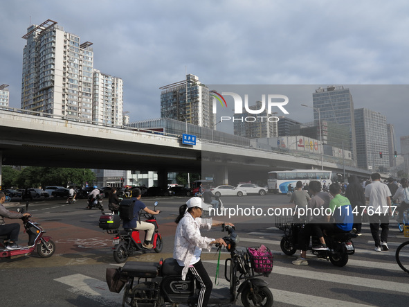 Pedestrians are riding on the streets of the CBD in Beijing, China, on August 14, 2024. 