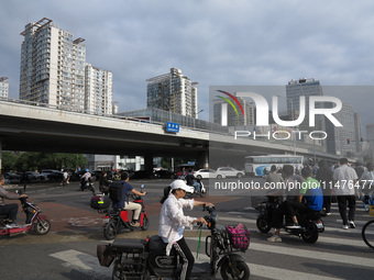 Pedestrians are riding on the streets of the CBD in Beijing, China, on August 14, 2024. (