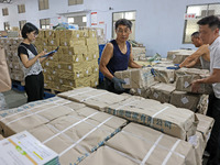 A staff member is carrying and arranging textbooks for the new semester at the textbook distribution center of New China Book Store in Zaozh...