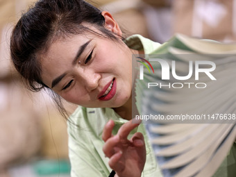 A staff member is carrying and arranging textbooks for the new semester at the textbook distribution center of New China Book Store in Zaozh...