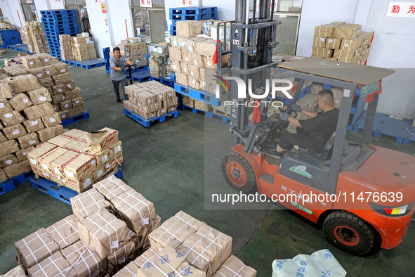 A staff member is carrying and arranging textbooks for the new semester at the textbook distribution center of New China Book Store in Zaozh...