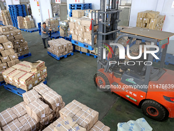 A staff member is carrying and arranging textbooks for the new semester at the textbook distribution center of New China Book Store in Zaozh...