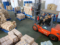 A staff member is carrying and arranging textbooks for the new semester at the textbook distribution center of New China Book Store in Zaozh...