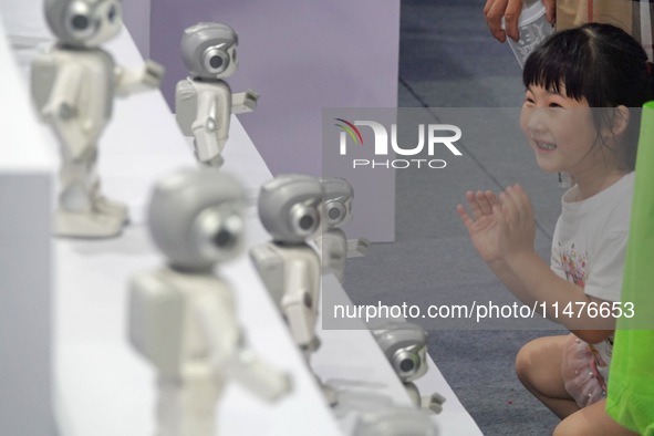 A child is watching a humanoid robot at a science popularization event in Yantai, China, on August 13, 2024. International investment bank G...