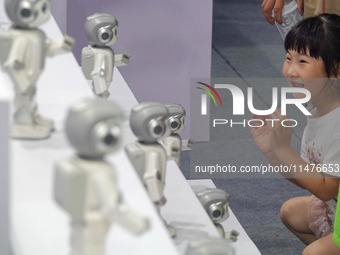 A child is watching a humanoid robot at a science popularization event in Yantai, China, on August 13, 2024. International investment bank G...