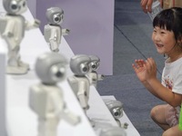 A child is watching a humanoid robot at a science popularization event in Yantai, China, on August 13, 2024. International investment bank G...