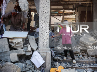 Palestinians are inspecting the rubble following overnight Israeli bombardment which is hitting the Abu Nada family home at the Nuseirat ref...