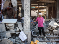 Palestinians are inspecting the rubble following overnight Israeli bombardment which is hitting the Abu Nada family home at the Nuseirat ref...