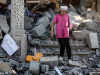 Palestinians are inspecting the rubble following overnight Israeli bombardment which is hitting the Abu Nada family home at the Nuseirat ref...