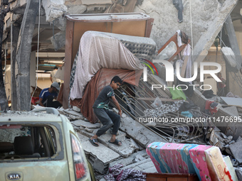 Palestinians are inspecting the rubble following overnight Israeli bombardment which is hitting the Abu Nada family home at the Nuseirat ref...