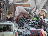 Palestinians are inspecting the rubble following overnight Israeli bombardment which is hitting the Abu Nada family home at the Nuseirat ref...