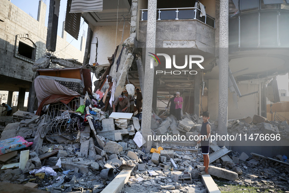 Palestinians are inspecting the rubble following overnight Israeli bombardment which is hitting the Abu Nada family home at the Nuseirat ref...