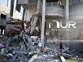 Palestinians are inspecting the rubble following overnight Israeli bombardment which is hitting the Abu Nada family home at the Nuseirat ref...