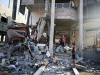 Palestinians are inspecting the rubble following overnight Israeli bombardment which is hitting the Abu Nada family home at the Nuseirat ref...