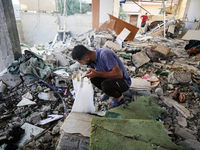 Palestinians are inspecting the rubble following overnight Israeli bombardment which is hitting the Abu Nada family home at the Nuseirat ref...