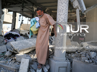 Palestinians are inspecting the rubble following overnight Israeli bombardment which is hitting the Abu Nada family home at the Nuseirat ref...