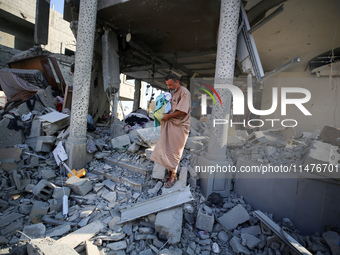 Palestinians are inspecting the rubble following overnight Israeli bombardment which is hitting the Abu Nada family home at the Nuseirat ref...