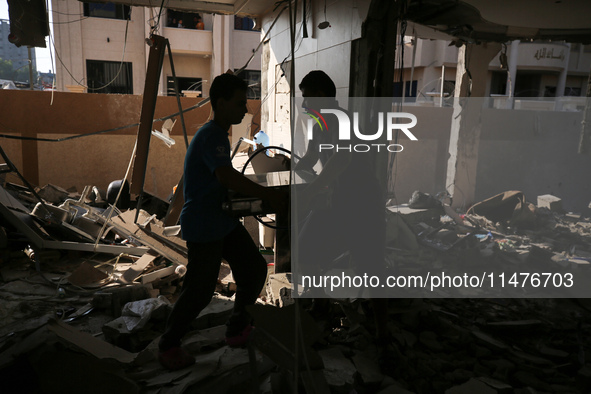 Palestinians are inspecting the rubble following overnight Israeli bombardment which is hitting the Abu Nada family home at the Nuseirat ref...