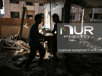 Palestinians are inspecting the rubble following overnight Israeli bombardment which is hitting the Abu Nada family home at the Nuseirat ref...